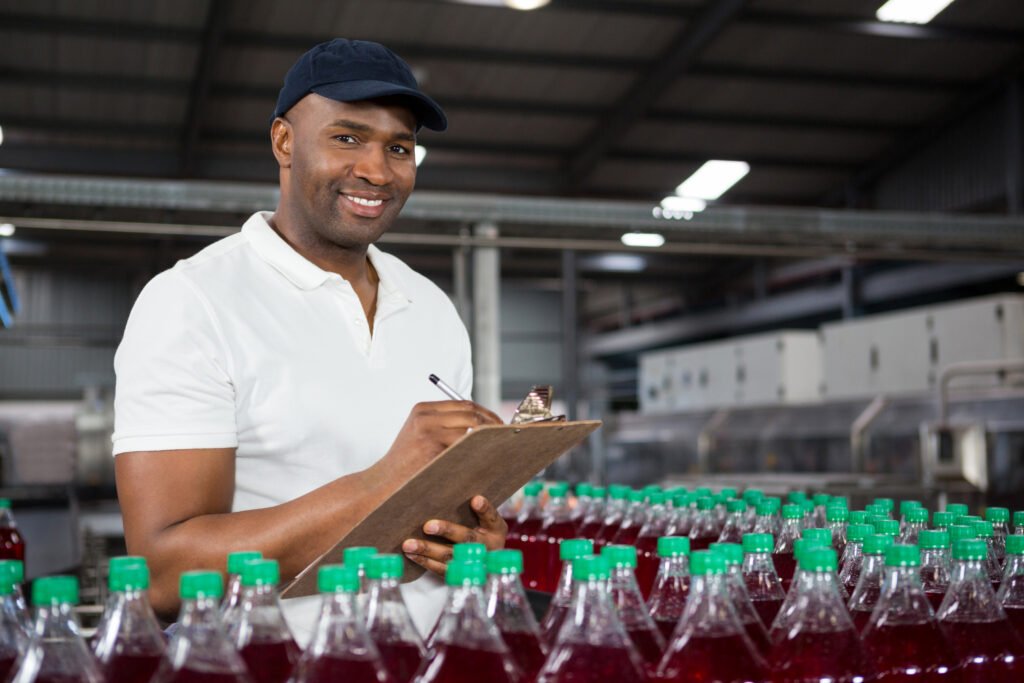 portrait of young male worker noting in juice factory